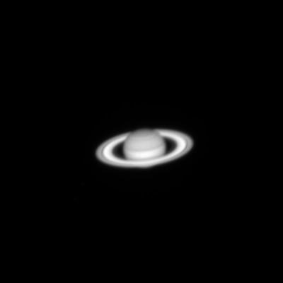 A small light grey sphere with a thick, flattened ring around it in the centre of the image against a black background. The sphere has darker bands running across its surface at different intervals. The ring has an outline of a darker band.